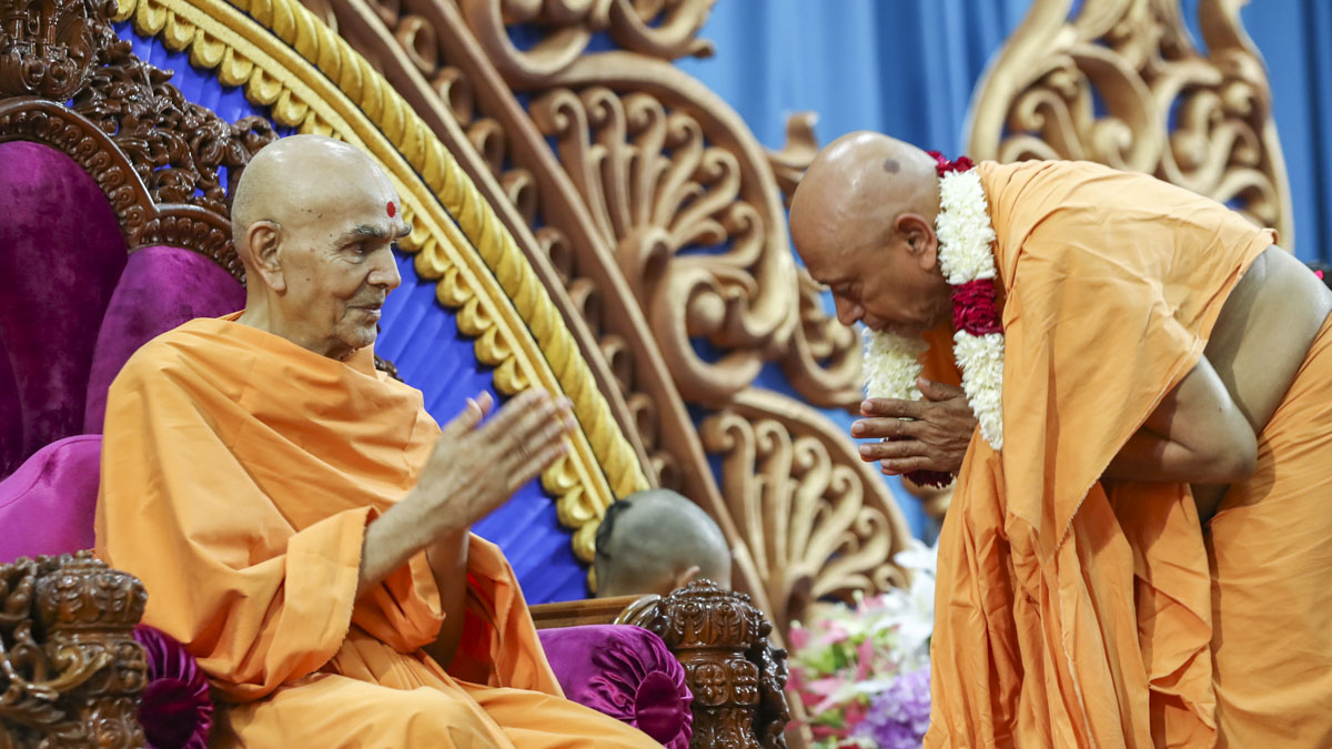 Swamishri welcomes Pujya Tyagvallabh Swami with a garland after his satsang tour of the Asia Pacific region, 8 Jun 2017