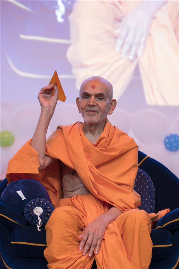 Swamishri flies a similar paper plane in the Bal-Balika Mandal shibir, in 2017