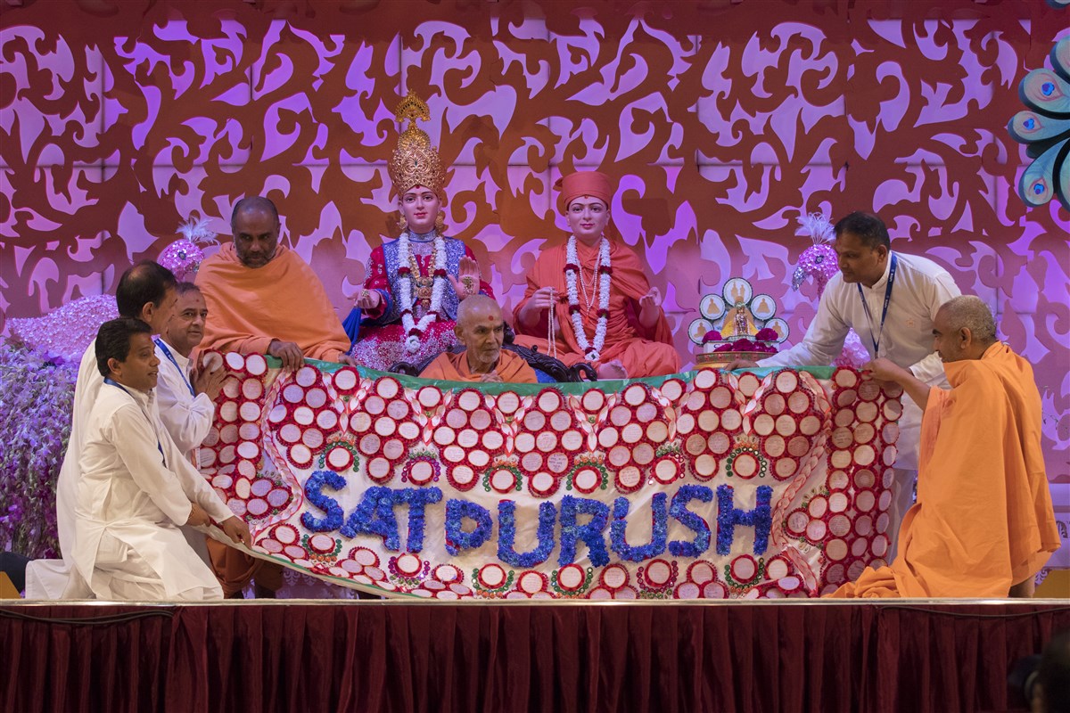 Lead sadhus and volunteers honour Swamishri with a decorative shawl