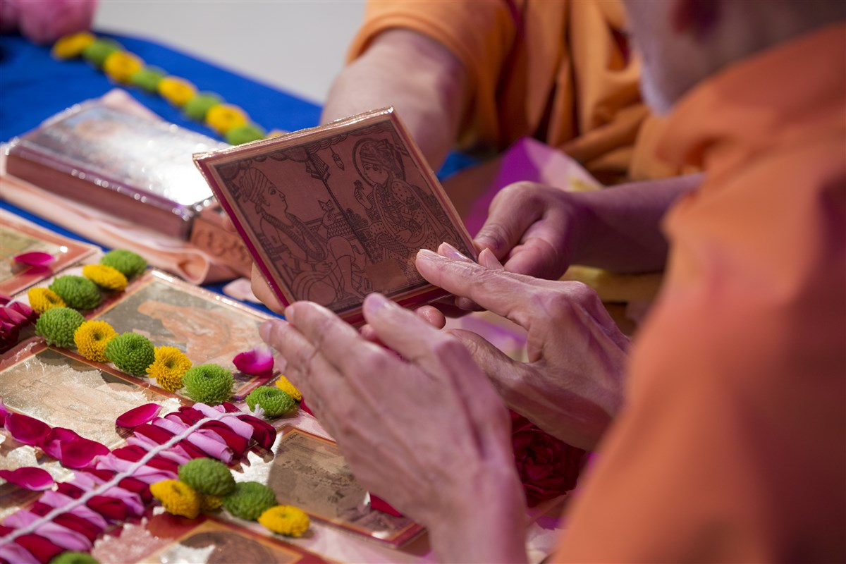 Swamishri reverentially touches the murtis in his puja