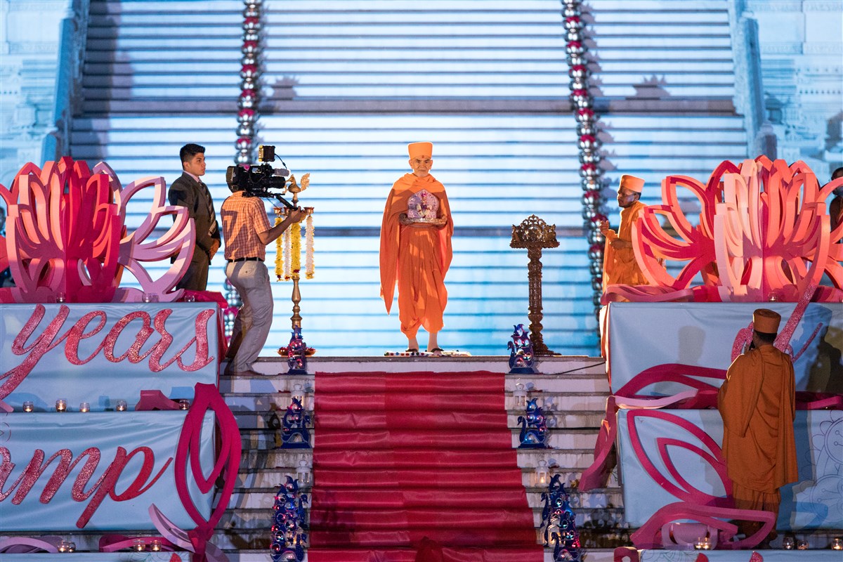 Swamishri in front of the mandir holding Shri Harikrishna Maharaj