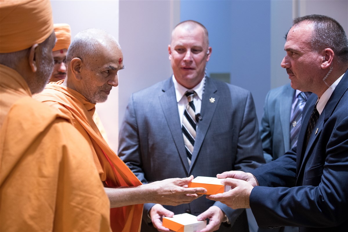 Swamishri meets with the Gwinnett County Sheriff's Department officers who provided escort from the airport