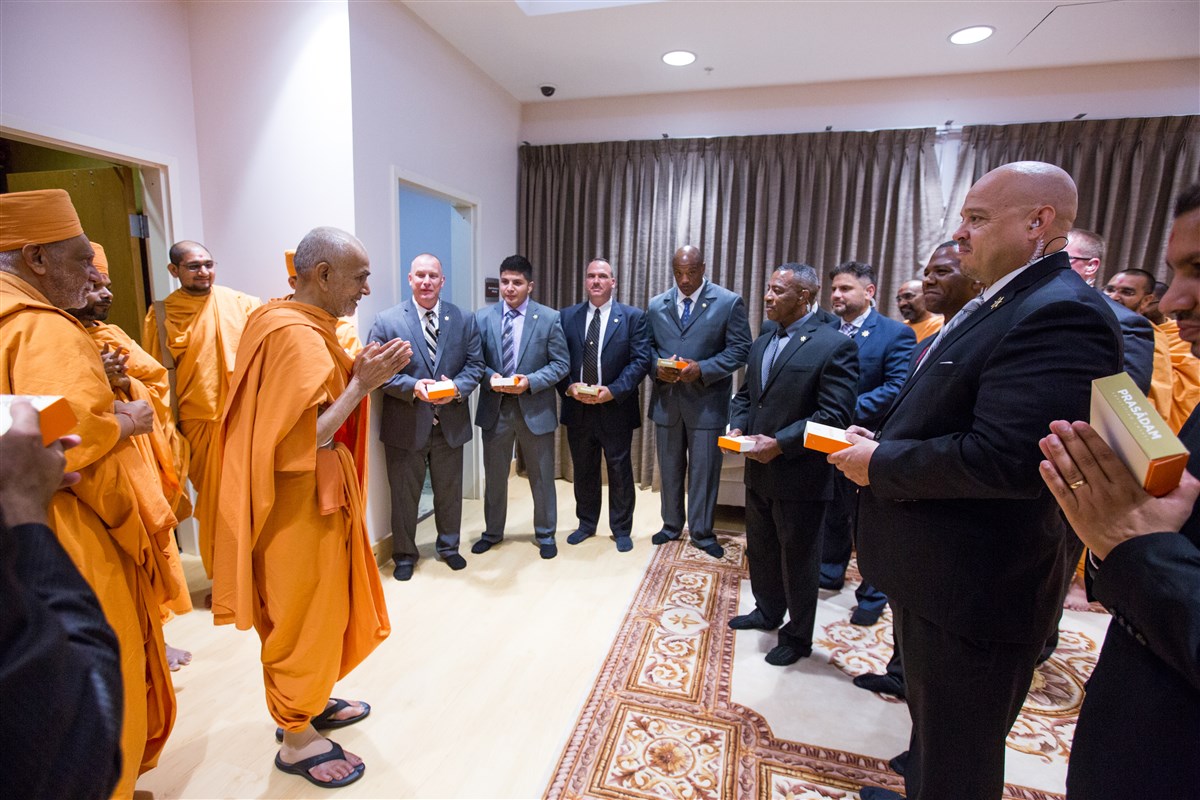 Swamishri meets with the Gwinnett County Sheriff's Department officers who provided escort from the airport