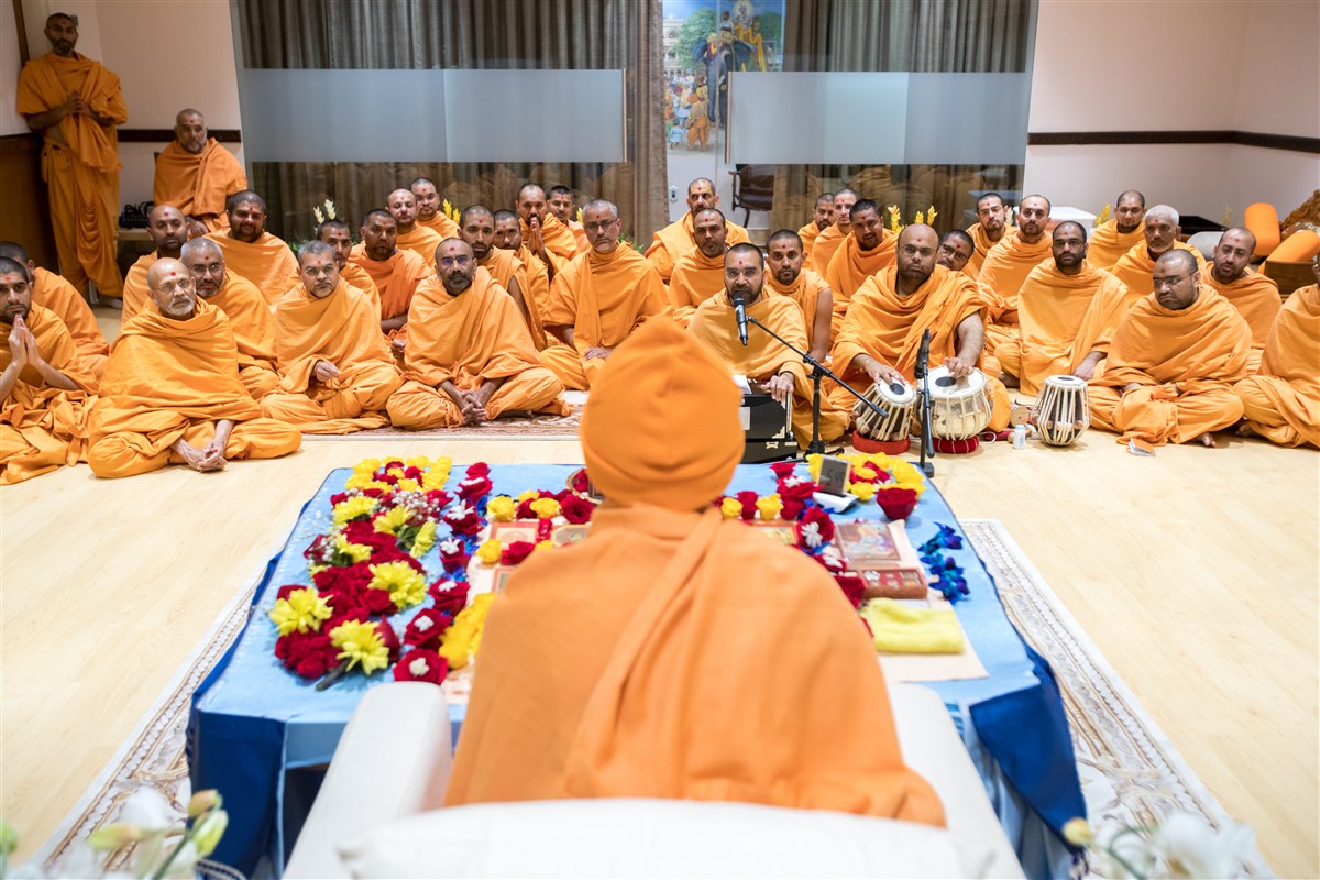 Pujya Swamis sing bhajans during Swamishri's puja