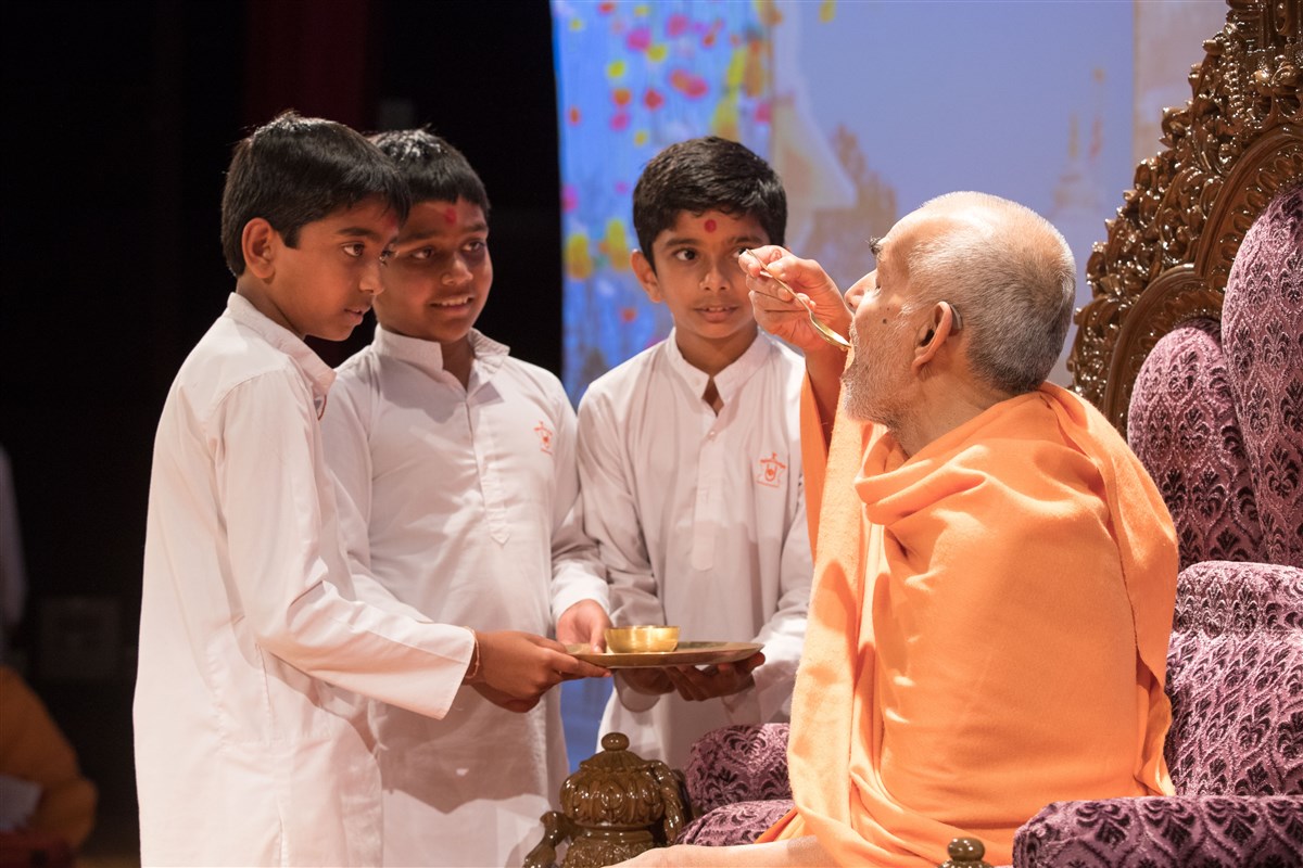 Children offer Swamishri sanctified water
