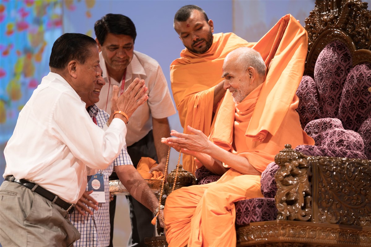Devotees present Swamishri with a shawl