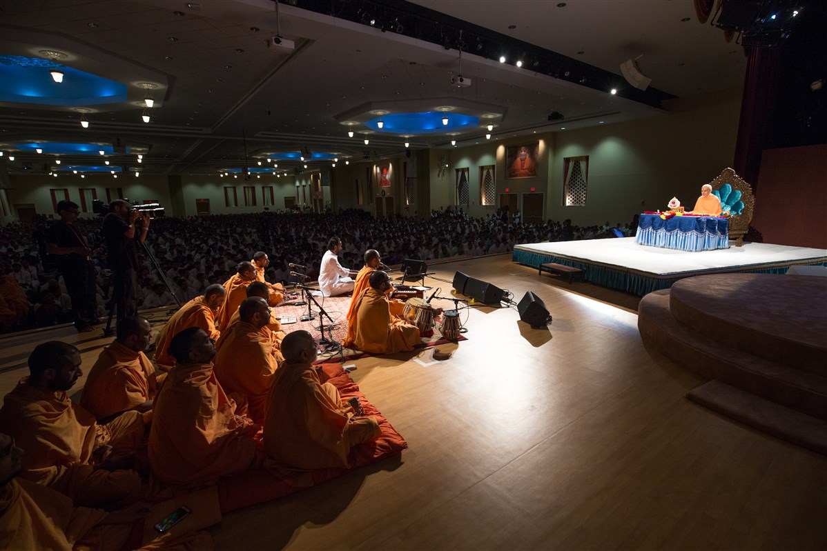 Swamis sing bhajans during Swamishri's puja