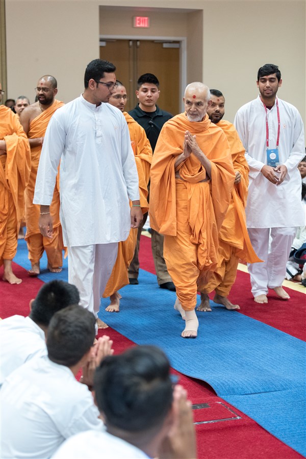 Swamishri enters the Kishore-Kishori Din program with his hands folded