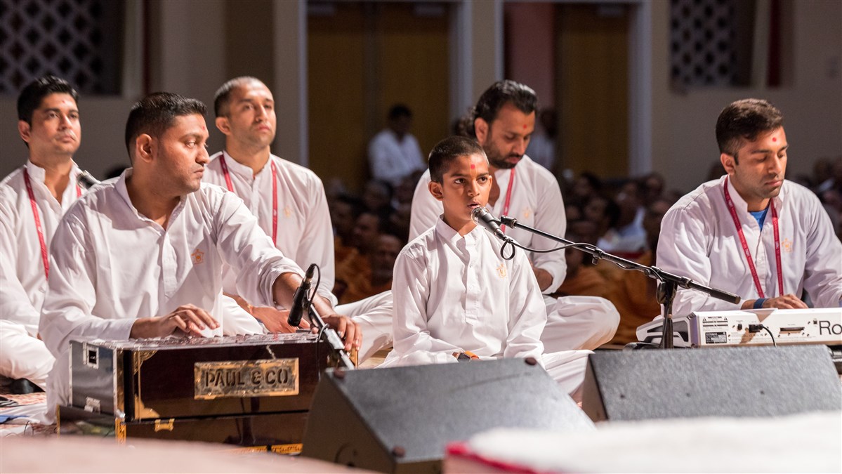 Youths sings kirtan during Swamishri's puja