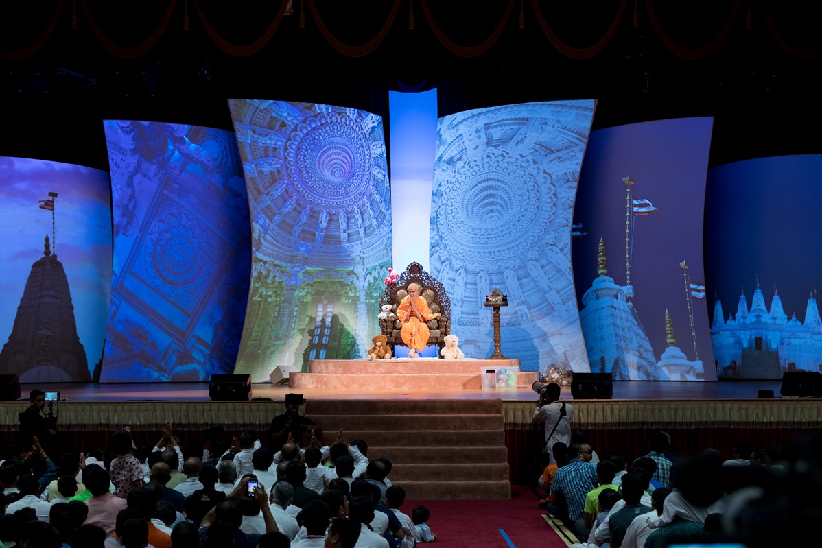 Swamishri folds his hands to the devotees in the audience