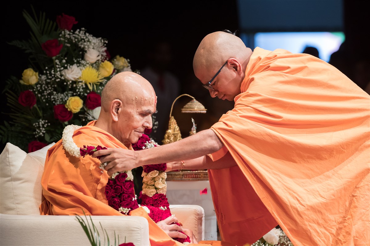 Pujya Shantmurtidas Swami offers Swamishri a garland