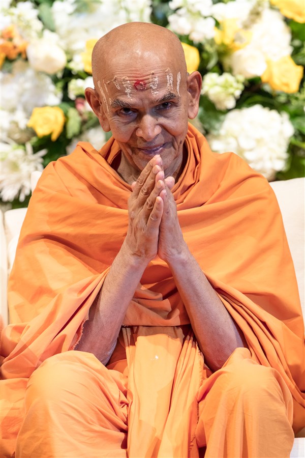 Swamishri folds his hands to the devotees in the audience