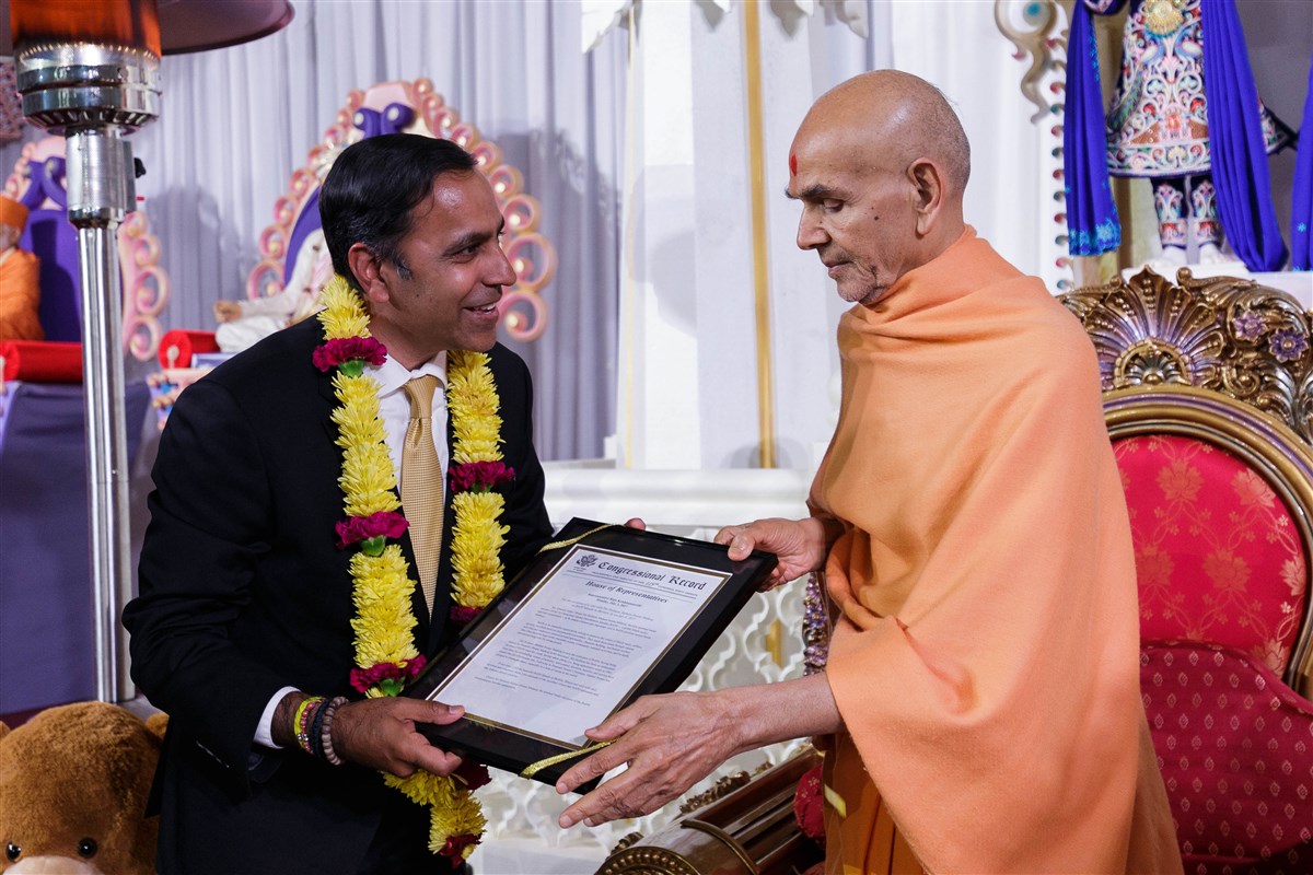 U.S. Congressman Raja Krishnamoorthi presents a proclamation to Swamishri