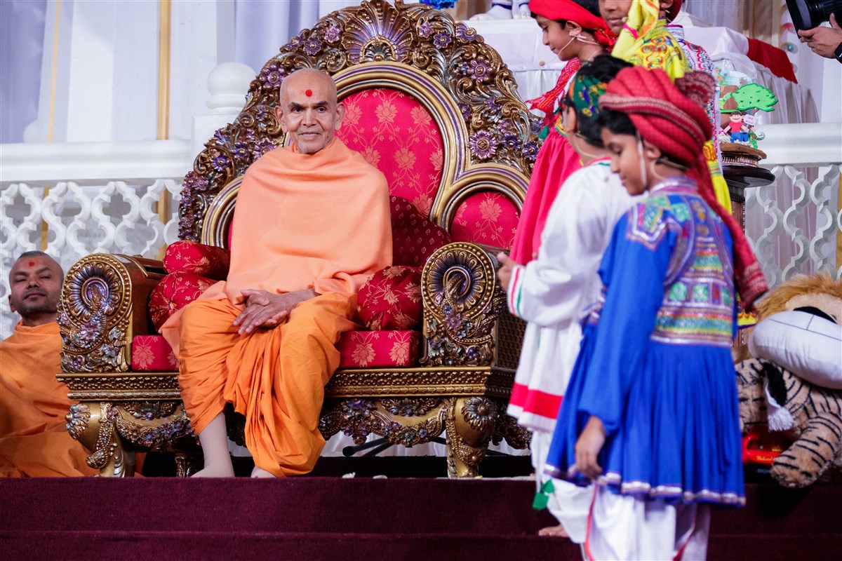 Swamishri attentively listens to children presenting