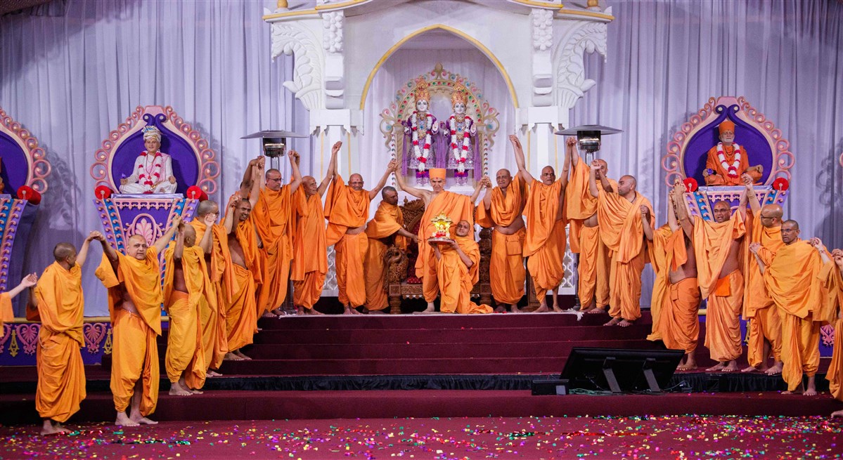Swamis join hands with Swamishri in a gesture of unity