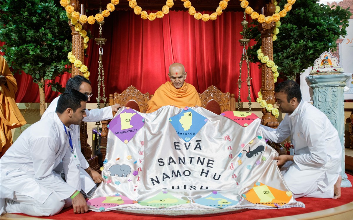 Youths honor Swamishri with a decorative shawl