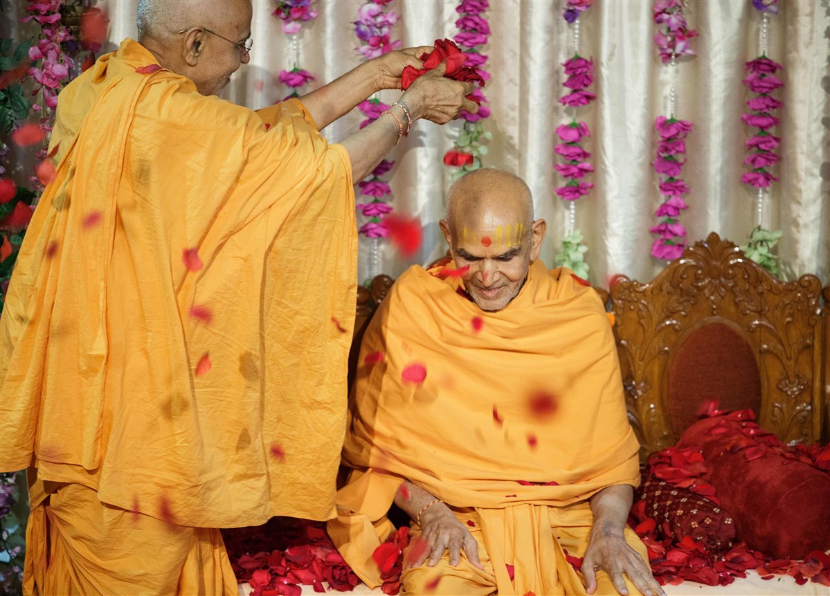 Swamishri is showered with flower petals