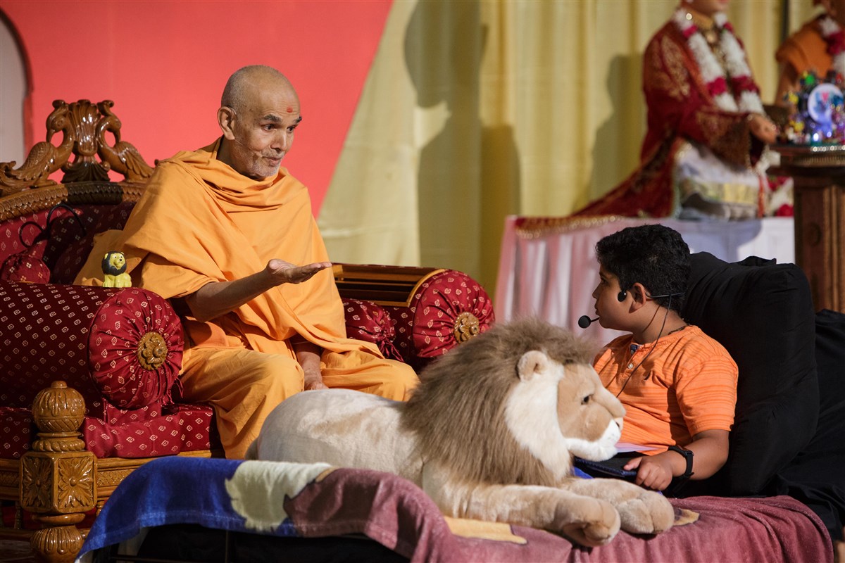 Swamishri interacts with a child