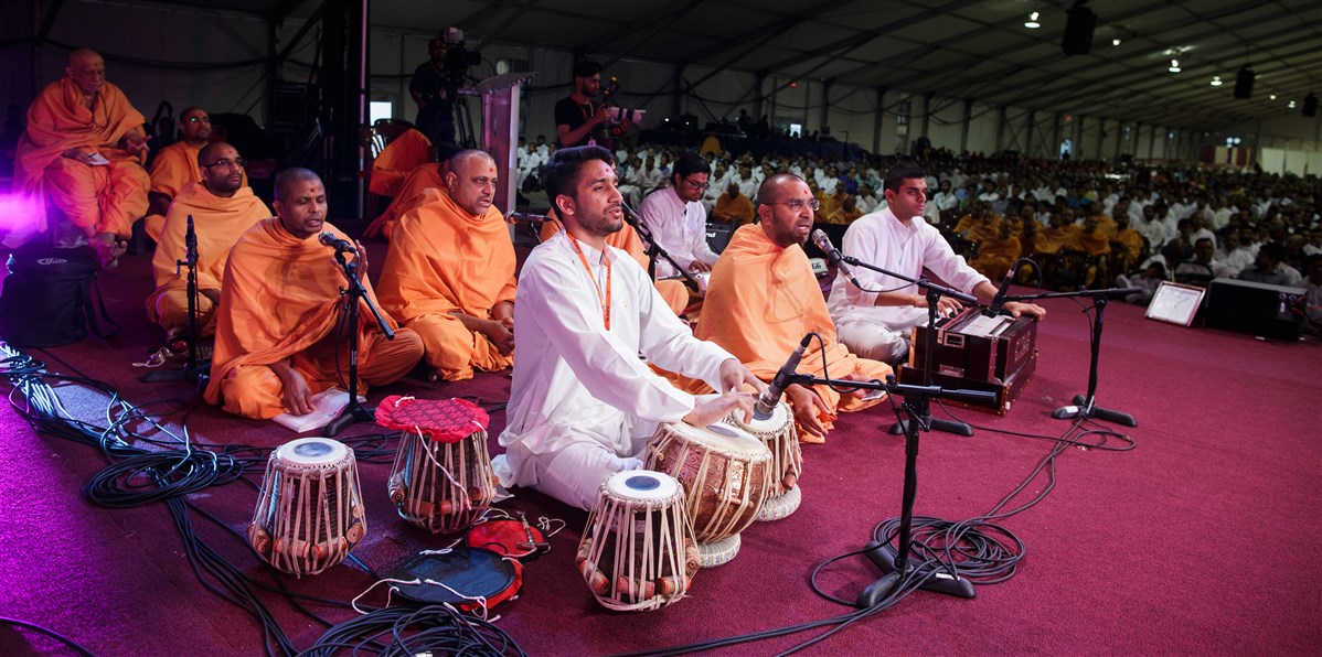 Swamis and devotees sing during Swamishri's puja