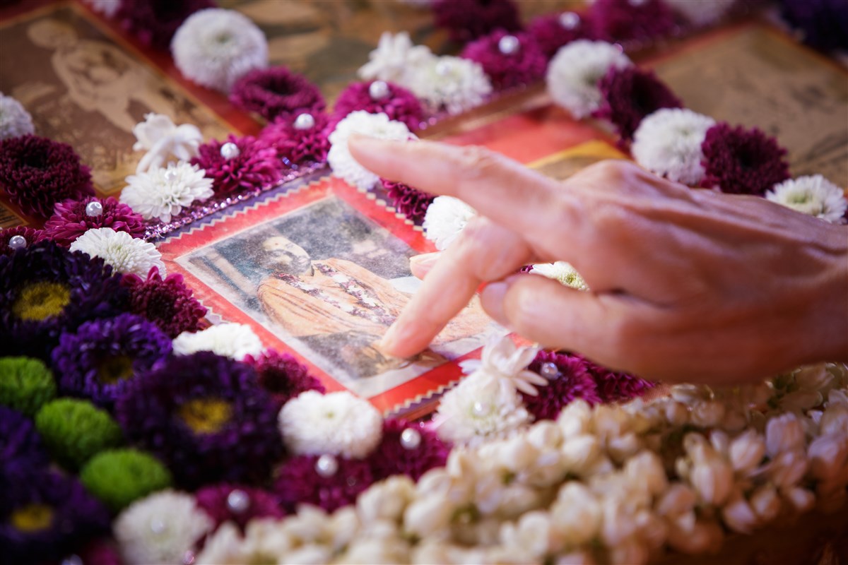 Swamishri touches the feet of the murti of Pramukh Swami Maharaj