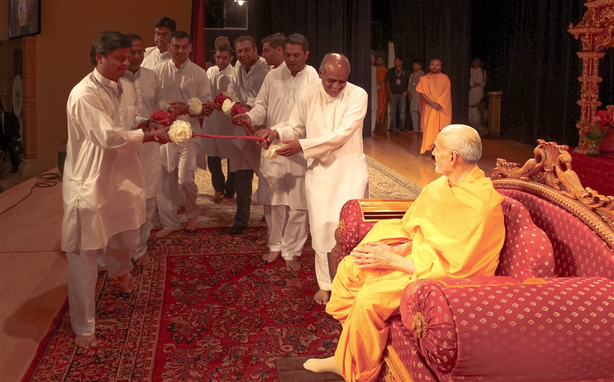 Devotees offer a garland to Swamishri, 18 July 2017