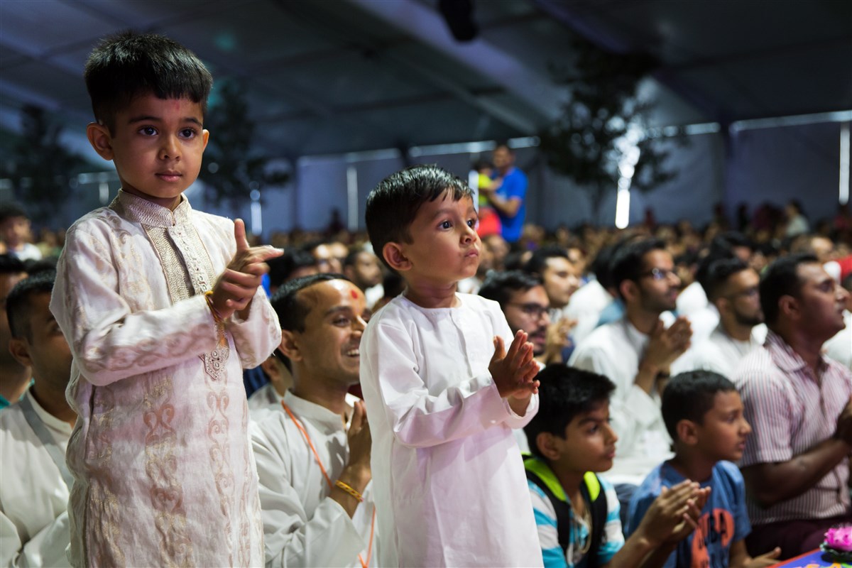 Children and devotees engrossed in Swamishri's darshan
