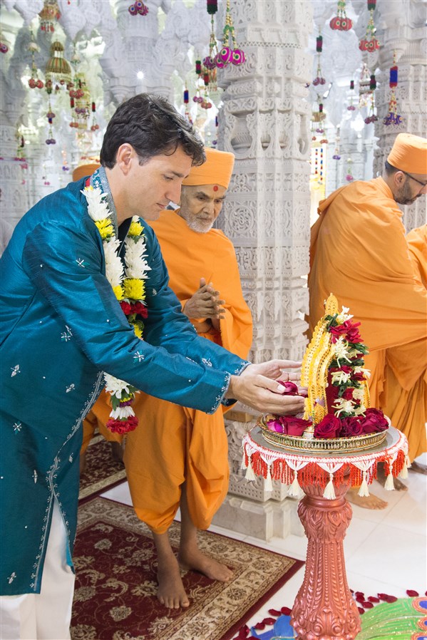 Prime Minister Justin Trudeau offers flowers to Shri Harikrishna Maharaj