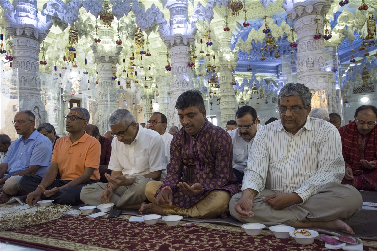 Devotees engrossed in the mahapuja rituals