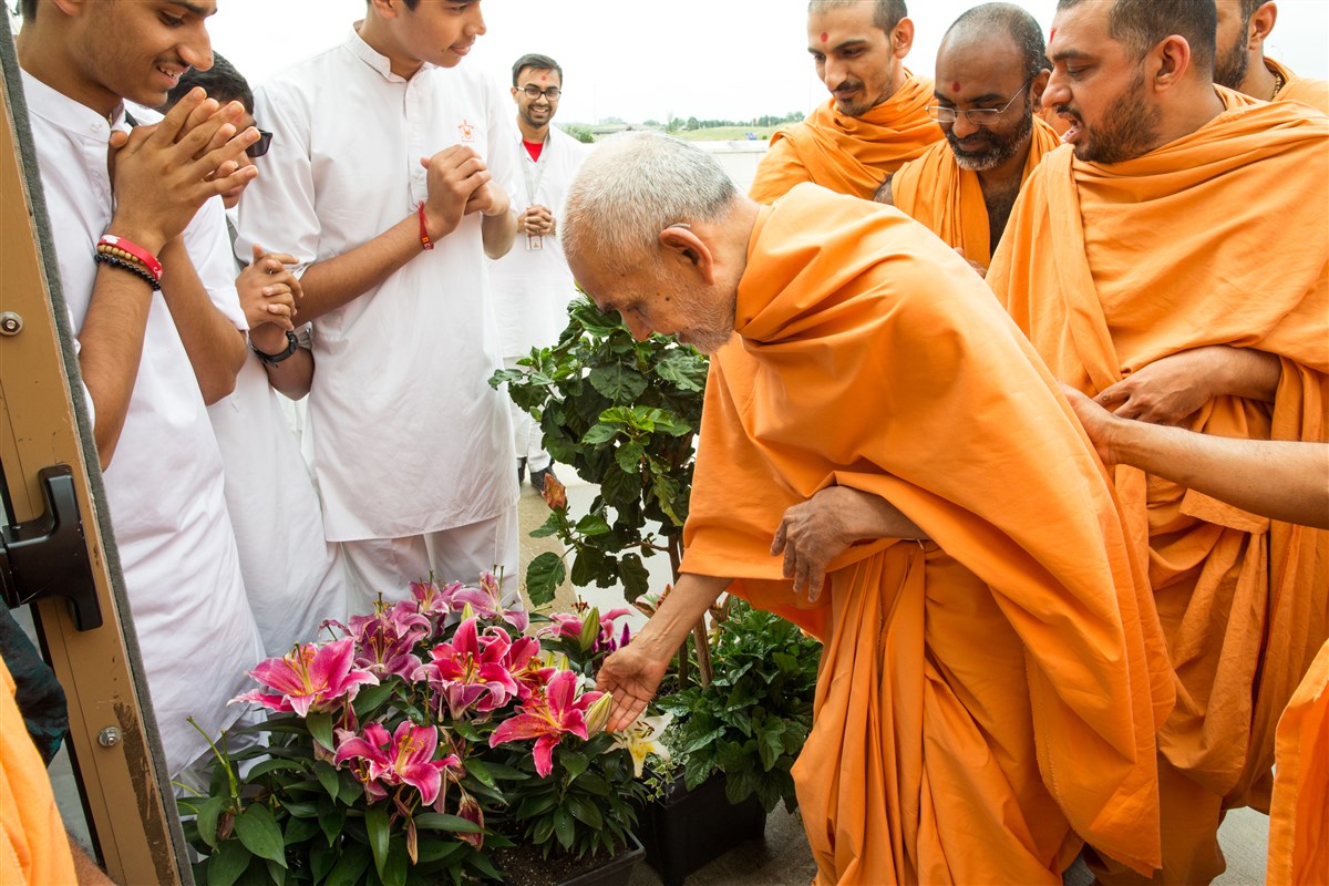Swamishri appreciates plants offered by a devotee