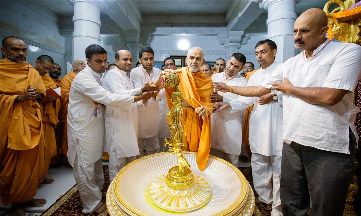 Swamishri performs abhishek with devotees
