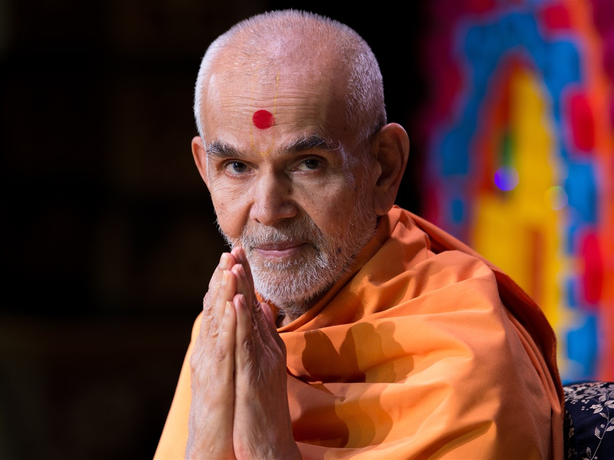 Swamishri folds his hands to devotees in the audience