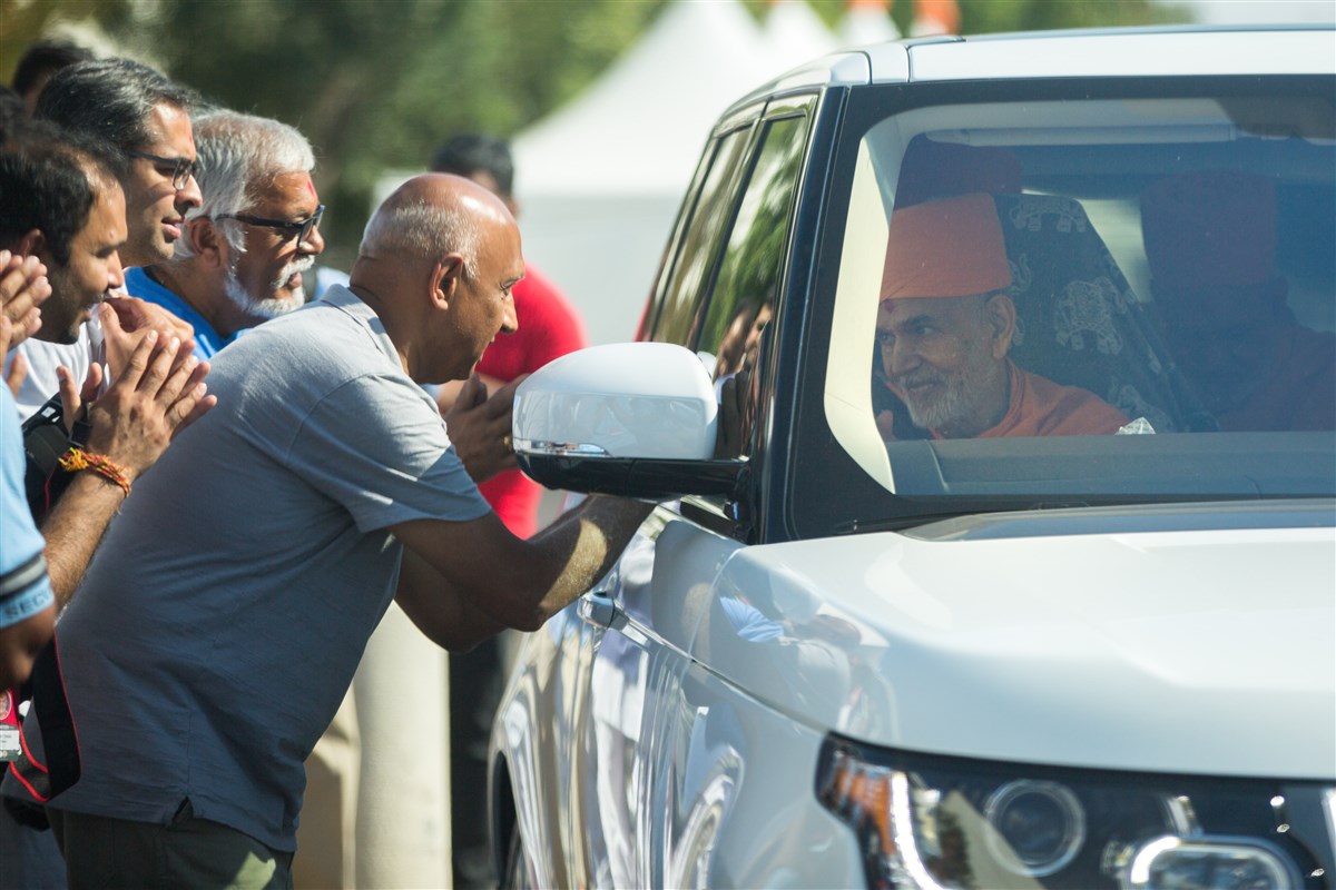 Swamishri greets devotees with folded hands 