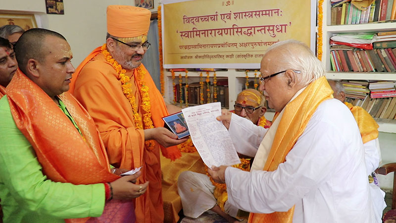Mahamahopadhyaya Acharya Shri Shivji Upadhyaya offers the letter of declaration to Shri Akshar-Purushottam Maharaj