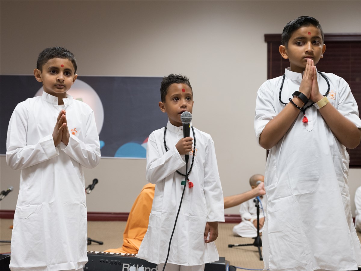 Children sing bhajans in Swamishri's puja