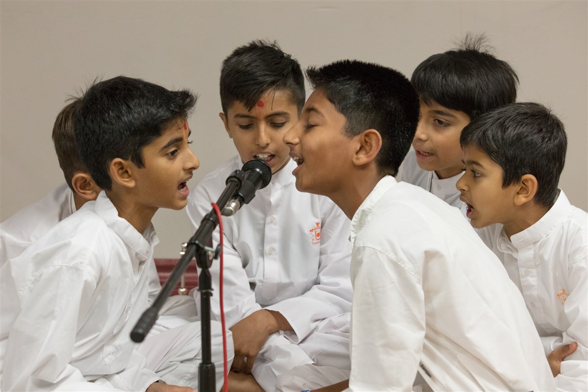 Children sing bhajans in Swamishri's puja
