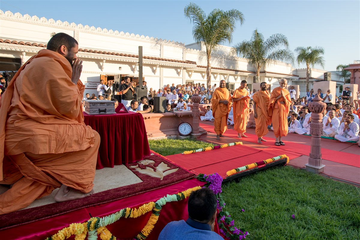 Param Pujya Mahant Swami Maharaj greets Swamis and devotees with folded hands
