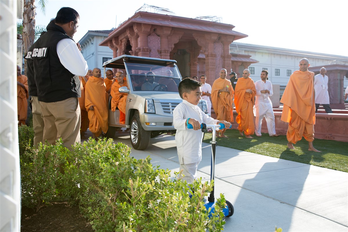 A child leads Swamishri towards the mandir