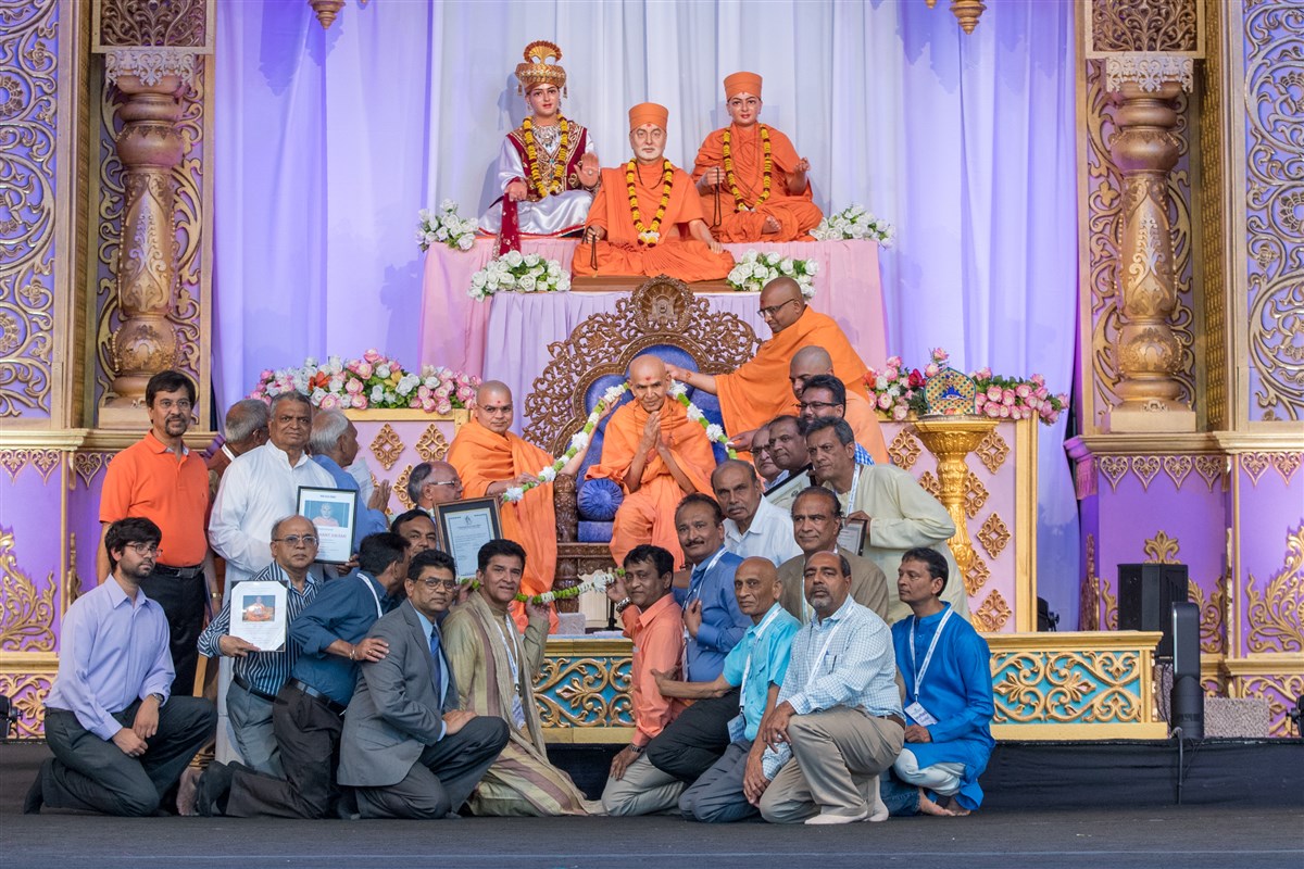 Swamishri is garlanded by heads of 20 different organizations in unity
