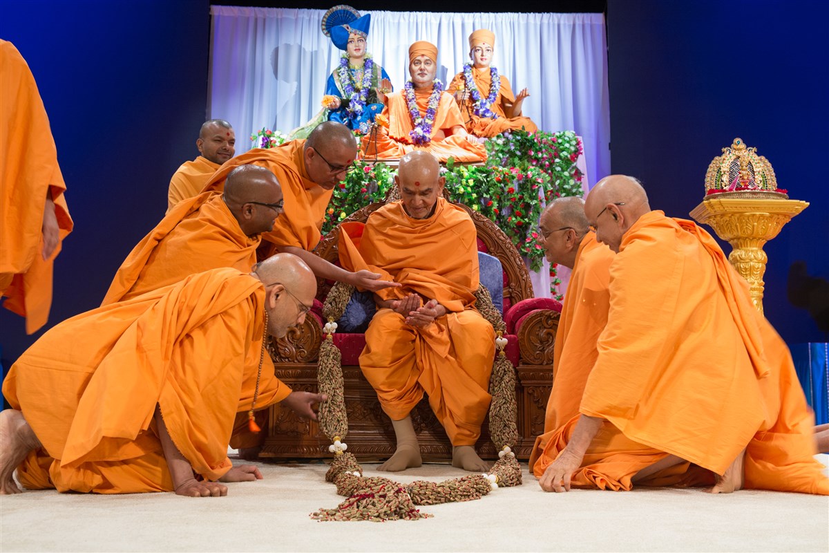 Swamis offer Swamishri a garland