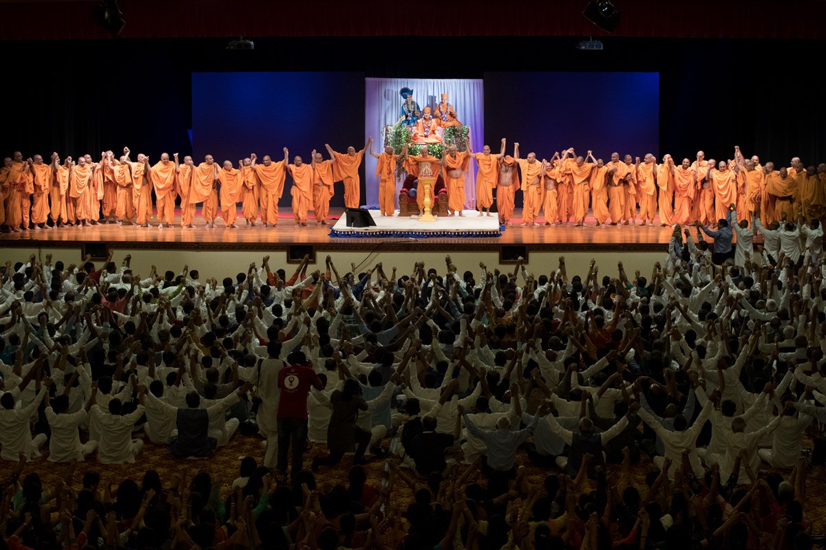 Param Pujya Mahant Swami Maharaj joins hands with swamis and youths in a gesture of unity