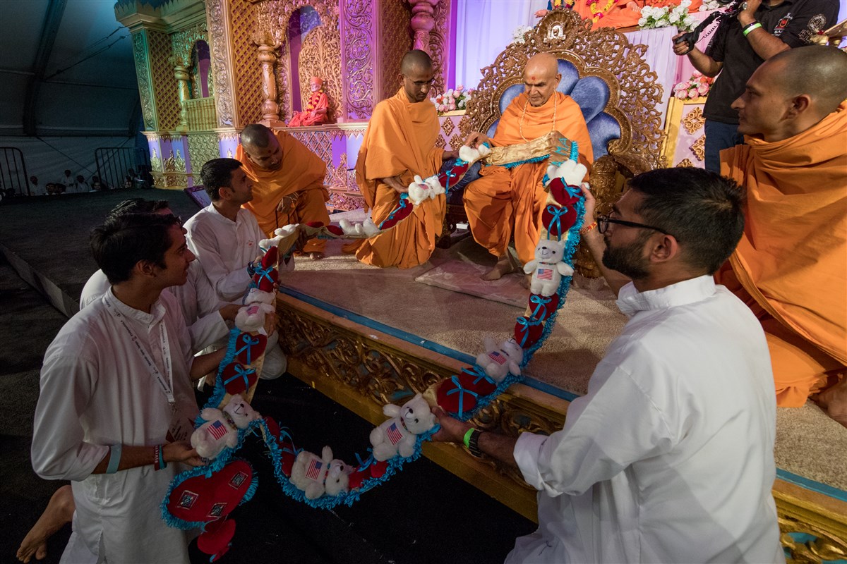 Youths offer Swamishri a garland