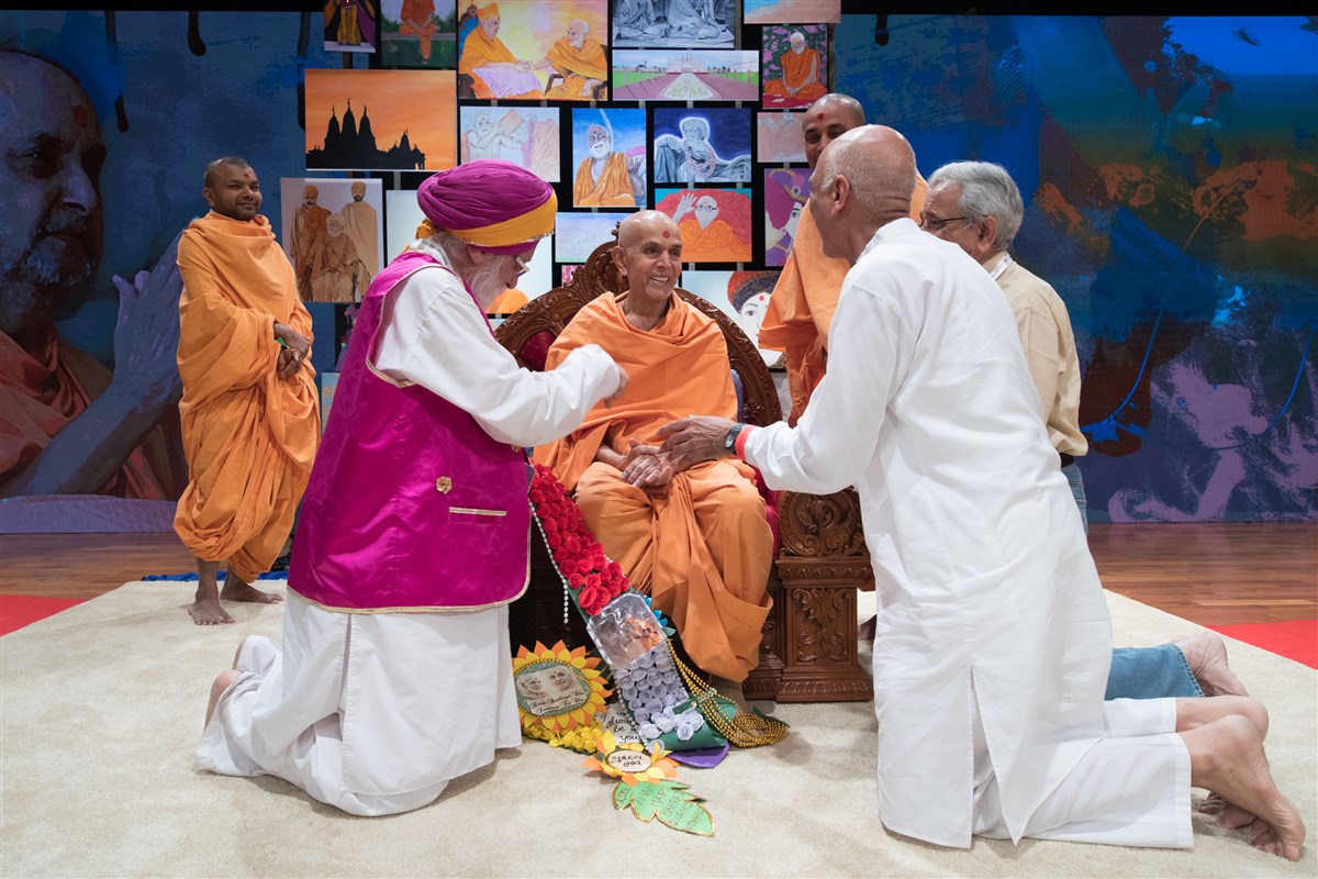 Devotees offer Swamishri a garland