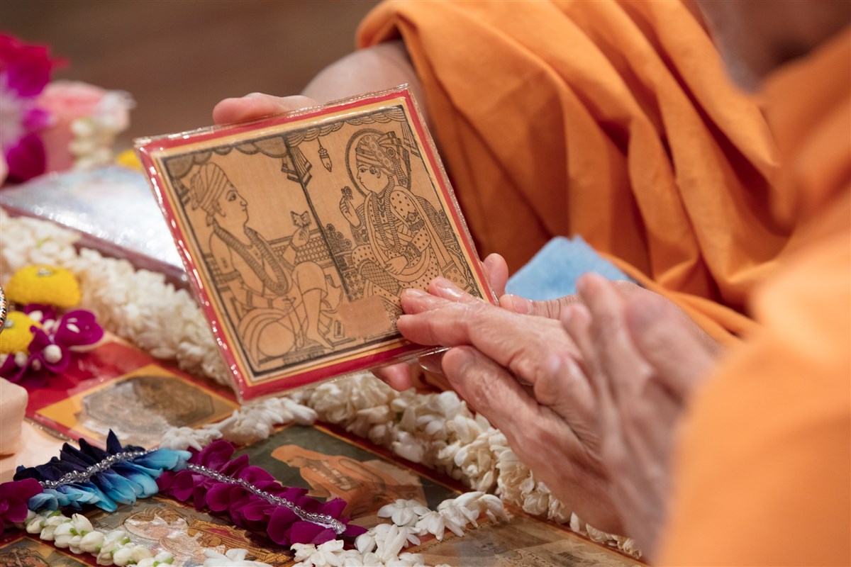 Swamishri touches the feet of the murti of Shri Akshar Purushottam Maharaj