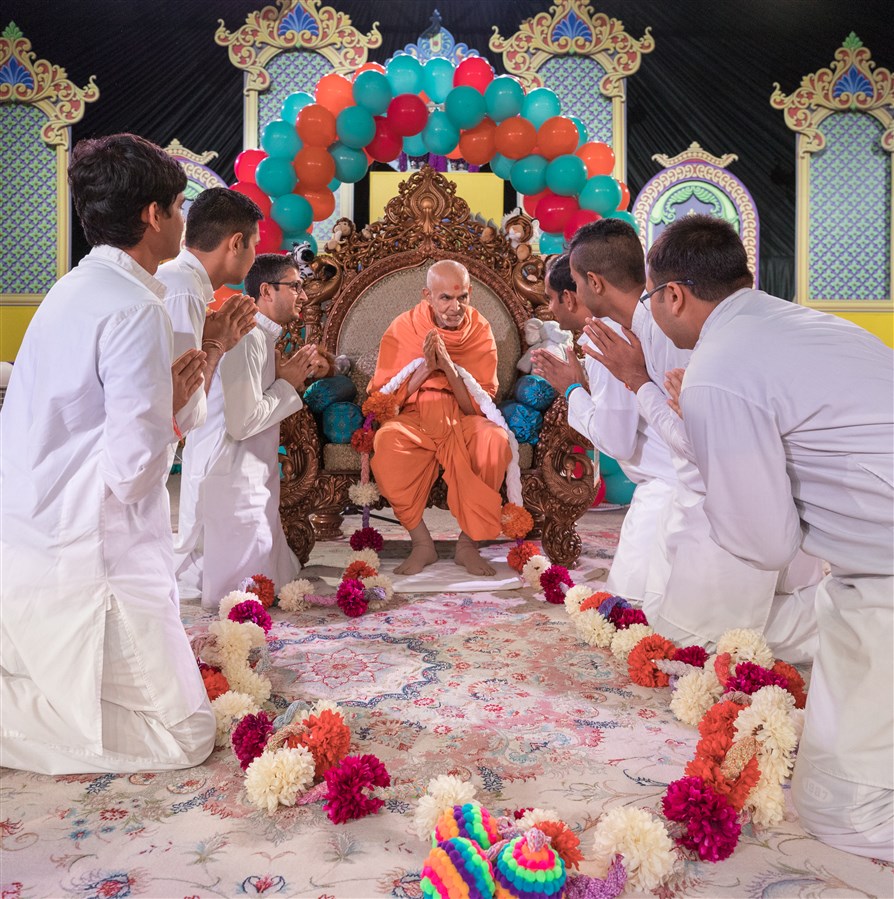 Devotees offer Swamishri a garland