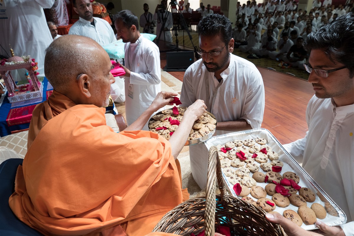 Swamishri sanctifies cookies for devotees
