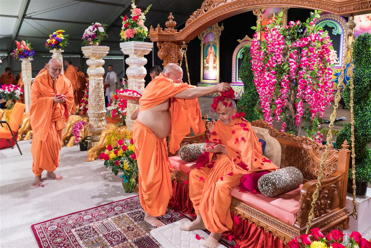 Pujya Ishwarcharandas Swami showers Swamishri with flowers, 19 August 2017