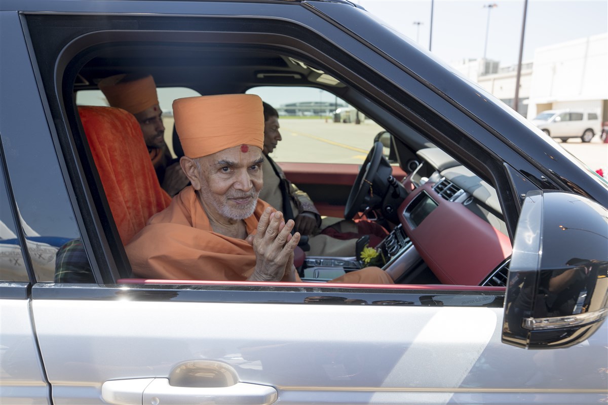 Param Pujya Mahant Swami Maharaj greets devotees with folded hands as he arrives