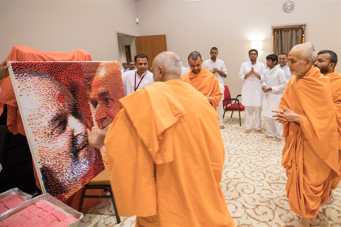 Swamishri views a bulletin board made of 18,000 thumb tacks depicting him and Brahmaswarup Pramukh Swami Maharaj, 23 August 2017