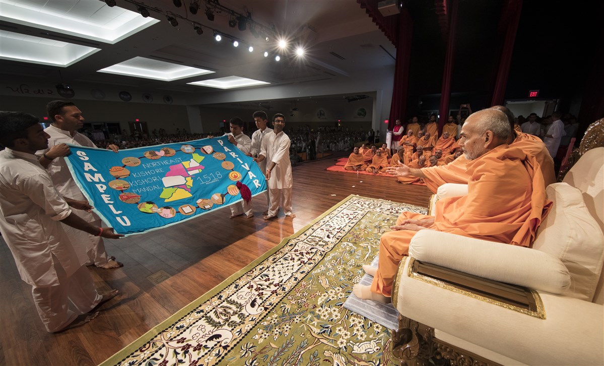 Kishore Mandal Karyakars present a shawl to Swamishri  