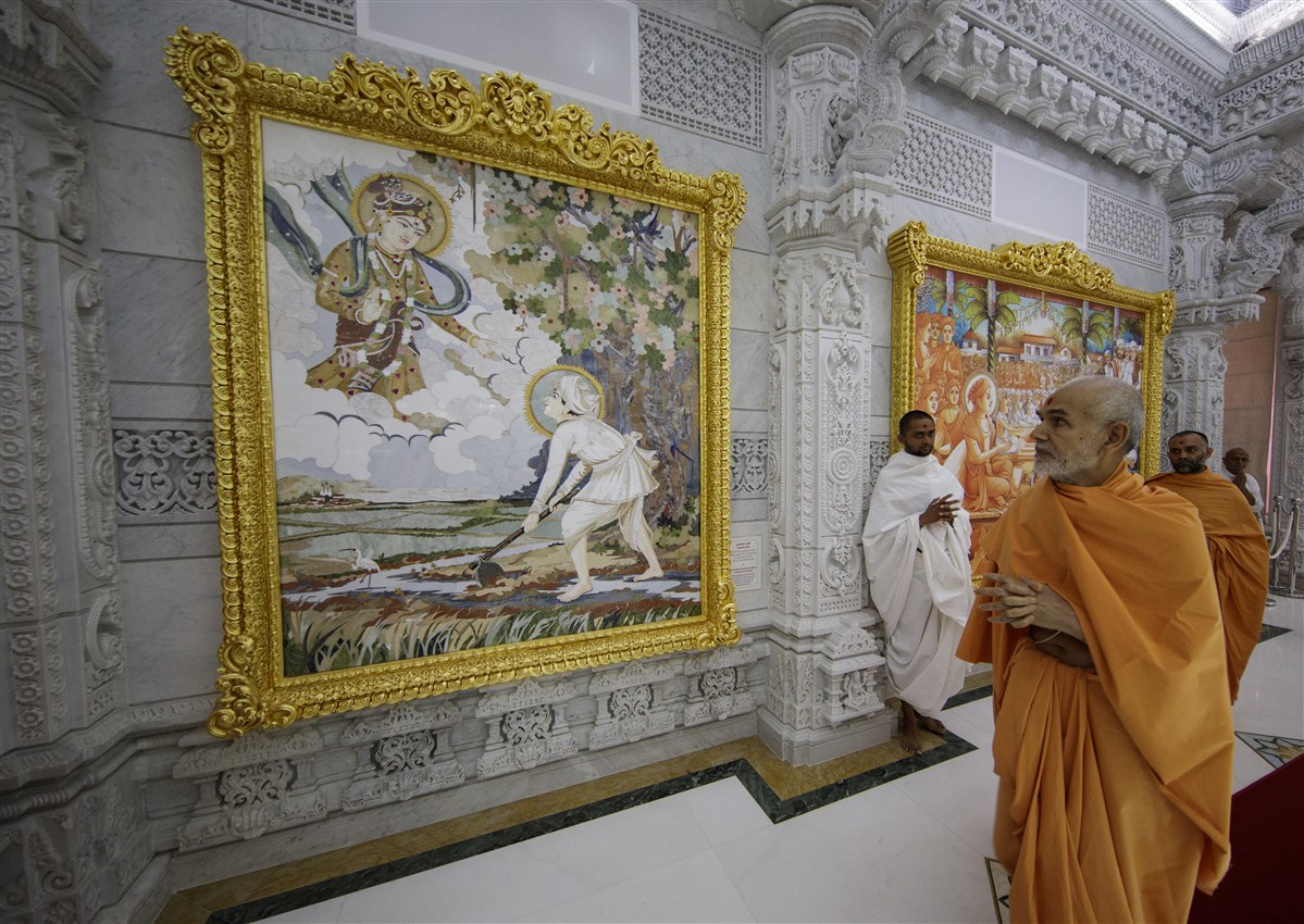 Swamishri observes murals around the mandir